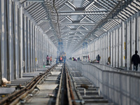 Labourers work on a newly constructed Ganga Rail Bridge built over the river Ganges at the Sangam area in Prayagraj, India, on December 10,...