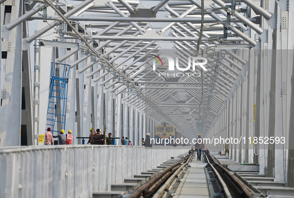 Labourers work on a newly constructed Ganga Rail Bridge built over the river Ganges at the Sangam area in Prayagraj, India, on December 10,...