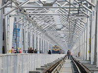 Labourers work on a newly constructed Ganga Rail Bridge built over the river Ganges at the Sangam area in Prayagraj, India, on December 10,...