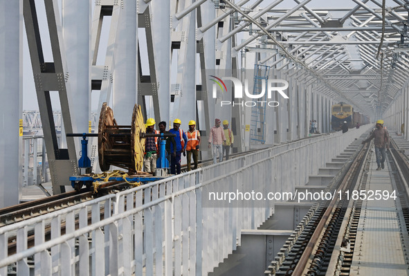 Labourers work on a newly constructed Ganga Rail Bridge built over the river Ganges at the Sangam area in Prayagraj, India, on December 10,...