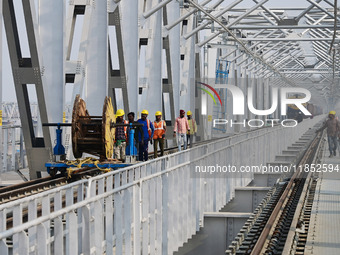 Labourers work on a newly constructed Ganga Rail Bridge built over the river Ganges at the Sangam area in Prayagraj, India, on December 10,...