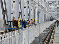 Labourers work on a newly constructed Ganga Rail Bridge built over the river Ganges at the Sangam area in Prayagraj, India, on December 10,...