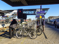 At Mühldorf station in Bavaria, Germany, on November 30, 2024, a small group of travelers waits patiently on the platform. The scene is calm...