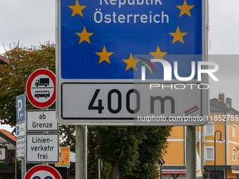 A blue border sign in Simbach, Germany, marks the boundary of the Schengen area between Germany and Austria, emphasizing the European Union’...