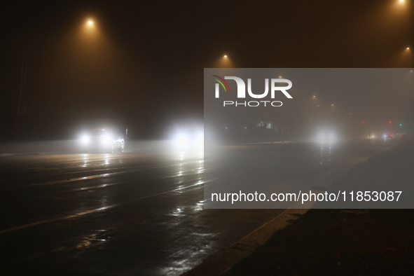 Drivers navigate the road as fog causing near-zero visibility blankets Toronto, Ontario, Canada, on December 9, 2024. 