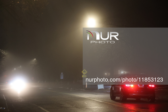 Drivers navigate the road as fog causing near-zero visibility blankets Toronto, Ontario, Canada, on December 9, 2024. 