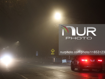 Drivers navigate the road as fog causing near-zero visibility blankets Toronto, Ontario, Canada, on December 9, 2024. (