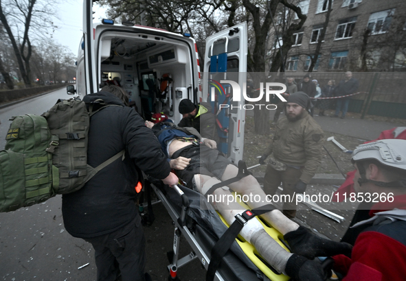 Paramedics place an injured person into an ambulance during a response effort to a Russian missile strike in Zaporizhzhia, Ukraine, on Decem...