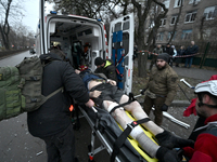 Paramedics place an injured person into an ambulance during a response effort to a Russian missile strike in Zaporizhzhia, Ukraine, on Decem...