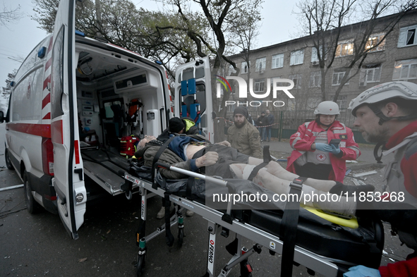 Paramedics place an injured person into an ambulance during a response effort to a Russian missile strike in Zaporizhzhia, Ukraine, on Decem...