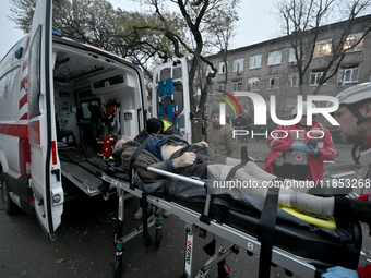 Paramedics place an injured person into an ambulance during a response effort to a Russian missile strike in Zaporizhzhia, Ukraine, on Decem...