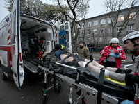 Paramedics place an injured person into an ambulance during a response effort to a Russian missile strike in Zaporizhzhia, Ukraine, on Decem...