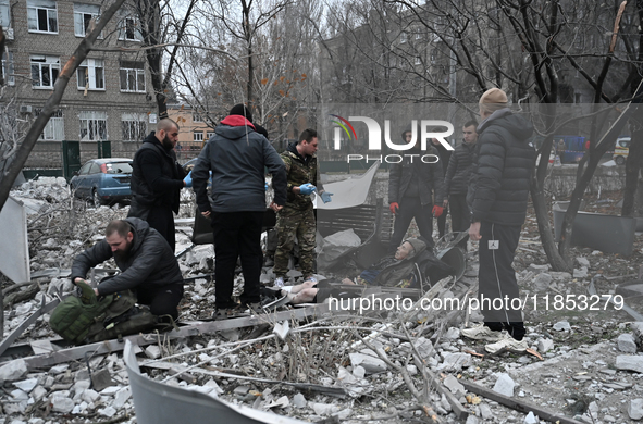 People stand by an elderly man injured by a Russian missile strike in Zaporizhzhia, Ukraine, on December 10, 2024. Three people are dead and...