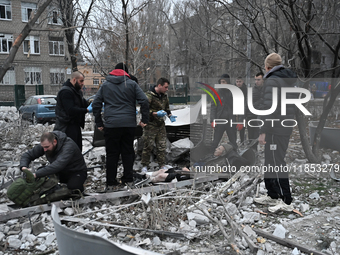 People stand by an elderly man injured by a Russian missile strike in Zaporizhzhia, Ukraine, on December 10, 2024. Three people are dead and...