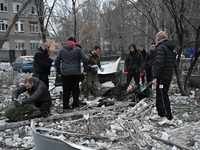 People stand by an elderly man injured by a Russian missile strike in Zaporizhzhia, Ukraine, on December 10, 2024. Three people are dead and...