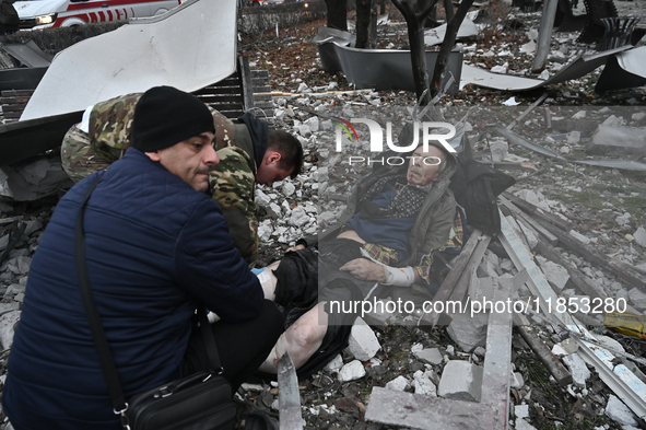 People stand by an elderly man injured by a Russian missile strike in Zaporizhzhia, Ukraine, on December 10, 2024. Three people are dead and...