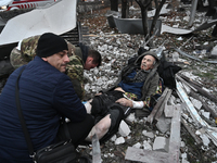 People stand by an elderly man injured by a Russian missile strike in Zaporizhzhia, Ukraine, on December 10, 2024. Three people are dead and...