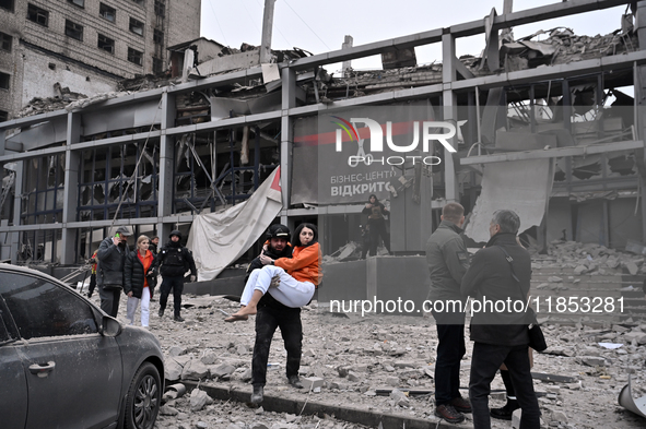 In Zaporizhzhia, Ukraine, on December 10, 2024, a police officer carries a woman rescued from a building destroyed by a Russian missile stri...