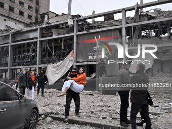 In Zaporizhzhia, Ukraine, on December 10, 2024, a police officer carries a woman rescued from a building destroyed by a Russian missile stri...