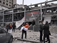 In Zaporizhzhia, Ukraine, on December 10, 2024, a police officer carries a woman rescued from a building destroyed by a Russian missile stri...