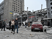 People stand outside a building destroyed by a Russian missile strike in Zaporizhzhia, Ukraine, on December 10, 2024. Three people die, and...