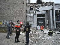 People stand outside a building destroyed by a Russian missile strike in Zaporizhzhia, Ukraine, on December 10, 2024. Three people die, and...