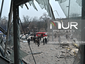 A broken window frames people in the street during a response effort to a Russian missile strike in Zaporizhzhia, Ukraine, on December 10, 2...