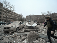 A police officer walks past cars crushed by the rubble after a Russian missile strike in Zaporizhzhia, Ukraine, on December 10, 2024. Three...