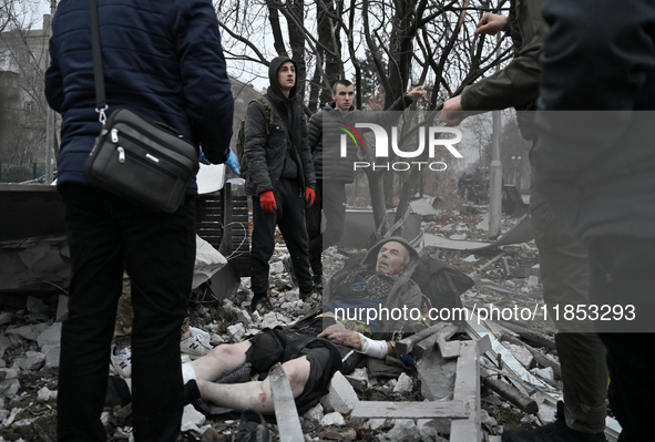 People stand by an elderly man injured by a Russian missile strike in Zaporizhzhia, Ukraine, on December 10, 2024. Three people are dead and...