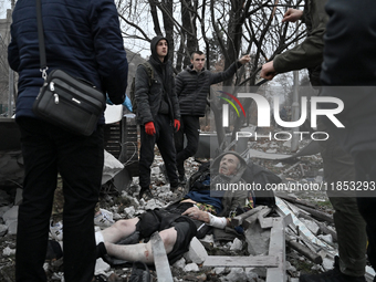 People stand by an elderly man injured by a Russian missile strike in Zaporizhzhia, Ukraine, on December 10, 2024. Three people are dead and...