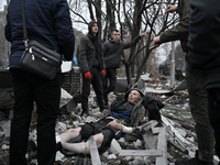 People stand by an elderly man injured by a Russian missile strike in Zaporizhzhia, Ukraine, on December 10, 2024. Three people are dead and...