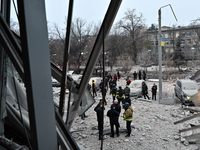 A broken window frames people in the street during a response effort to a Russian missile strike in Zaporizhzhia, Ukraine, on December 10, 2...