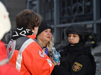 In Zaporizhzhia, Ukraine, on December 10, 2024, a Ukrainian Red Cross Society member and a police officer assist a woman crying near a build...