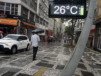 People walk with their umbrellas on a cloudy and rainy day in the center of Sao Paulo, Brazil, on December 10, 2024. (