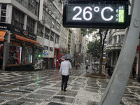 People walk with their umbrellas on a cloudy and rainy day in the center of Sao Paulo, Brazil, on December 10, 2024. (