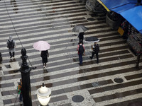 People walk with their umbrellas on a cloudy and rainy day in the center of Sao Paulo, Brazil, on December 10, 2024. (