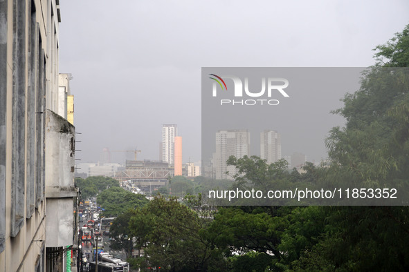 People walk with their umbrellas on a cloudy and rainy day in the center of Sao Paulo, Brazil, on December 10, 2024. 