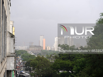 People walk with their umbrellas on a cloudy and rainy day in the center of Sao Paulo, Brazil, on December 10, 2024. (