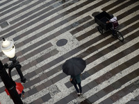 People walk with their umbrellas on a cloudy and rainy day in the center of Sao Paulo, Brazil, on December 10, 2024. (