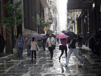 People walk with their umbrellas on a cloudy and rainy day in the center of Sao Paulo, Brazil, on December 10, 2024. (