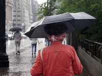 People walk with their umbrellas on a cloudy and rainy day in the center of Sao Paulo, Brazil, on December 10, 2024. (