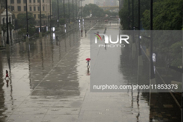 People walk with their umbrellas on a cloudy and rainy day in the center of Sao Paulo, Brazil, on December 10, 2024. 