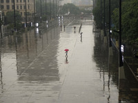 People walk with their umbrellas on a cloudy and rainy day in the center of Sao Paulo, Brazil, on December 10, 2024. (