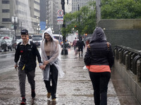 People walk with their umbrellas on a cloudy and rainy day in the center of Sao Paulo, Brazil, on December 10, 2024. (