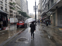 People walk with their umbrellas on a cloudy and rainy day in the center of Sao Paulo, Brazil, on December 10, 2024. (