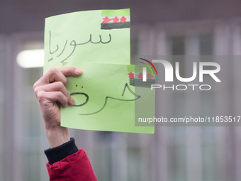 The sign of ''freedom Syria'' is seen as more than a hundred people celebrate post Al Assad in front of Duisburg Central Station in Duisburg...