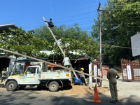 Workers install new electricity poles in Kottarakkara, Kollam, Kerala, India, on April 6, 2024. (