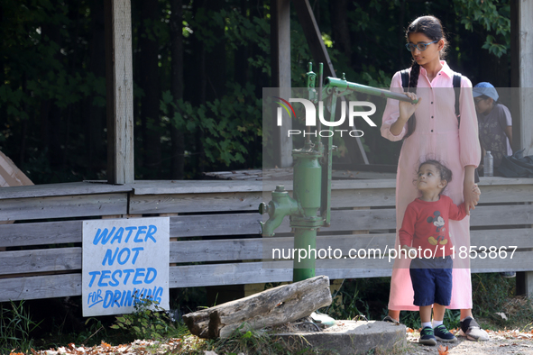 A young girl from India looks at an antique water pump at a farm in Stouffville, Ontario, Canada, on September 22, 2024. 