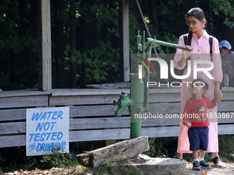 A young girl from India looks at an antique water pump at a farm in Stouffville, Ontario, Canada, on September 22, 2024. (