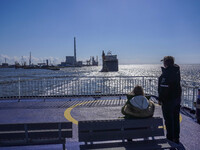 People look at the ships in Esbjerg port in Nordby, Fano Island, Denmark, on April 29, 2024. (